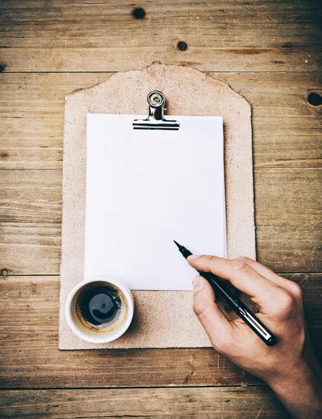 Clipboard de couro vintage com página em branco e caneta mão segurando — Fotografia de Stock