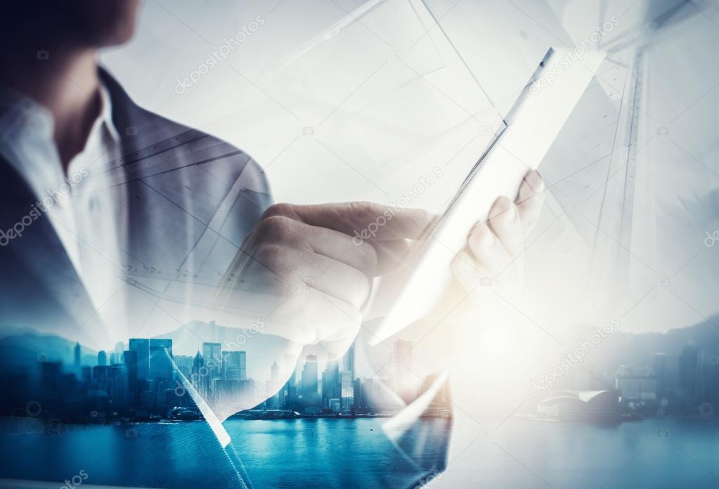 Double exposure of city and business man using digital tablet