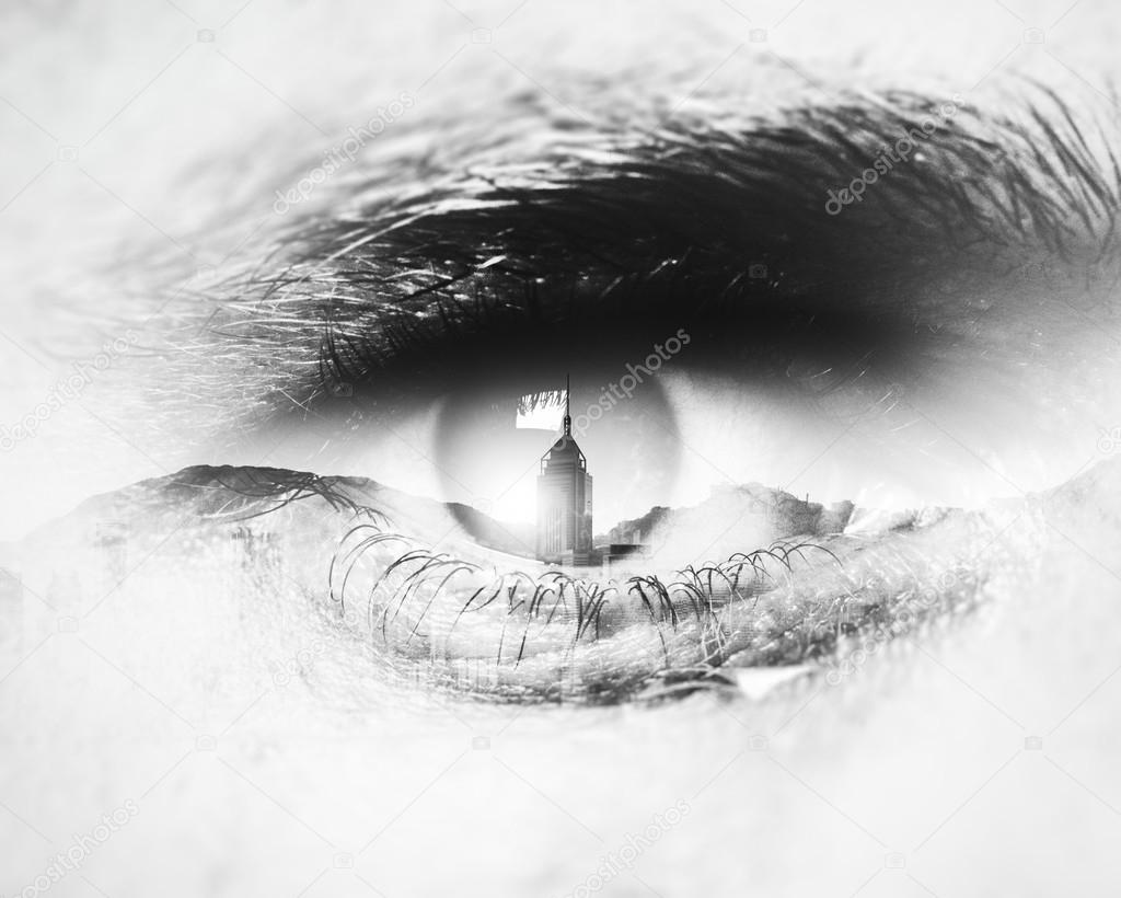 Bw close-up of human eye with visual effects. Double exposure  skyscrapers and mountains. Horizontal