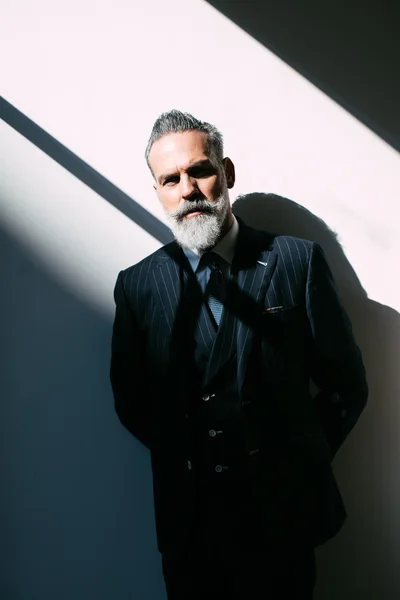 Portrait of stylish bearded man wearing trendy suit and stands against the wall. Vertical — 图库照片