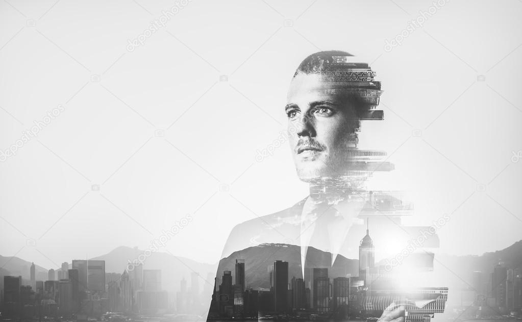 BW multiexposure of young businessman and sunrise in contemporary city on the background