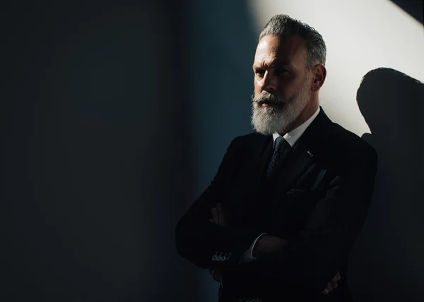 Portrait of stylish bearded man wearing trendy suit and stands against the wall. Horizontal — Stock Photo, Image