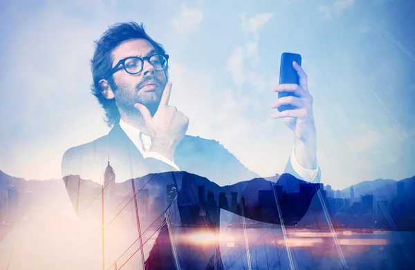 Dupla exposição do homem vestindo terno na moda e faz selfe em seu smartphone . — Fotografia de Stock