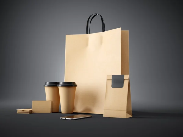 Set of brown pocket bag, two coffee cups, business cards and generic design smartphone. Dark background. 3d render — 图库照片