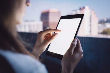 Kız onun tablet bulanık şehir arka plan üzerinde ekran dokunaklı. Yatay