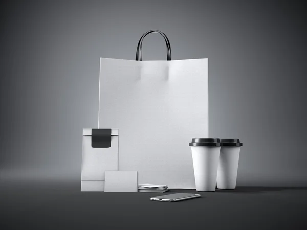 Set of white craft shopping bag, two coffee cups, business cards and generic design smartphone. Dark background. 3d render — Stok fotoğraf