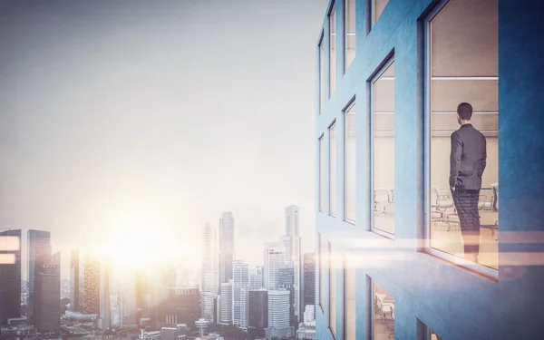 Zakenman binnen wolkenkrabber, zoekt in het city via venster. Horizontale — Stockfoto