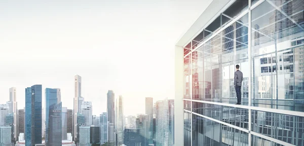 Businessman inside skyscraper, lookng at the city through  window on sunrise — Stock Photo, Image