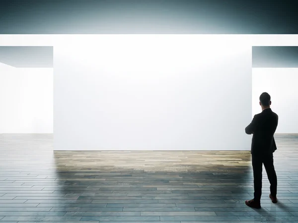 Businessman opposite big white wall — Stock Photo, Image