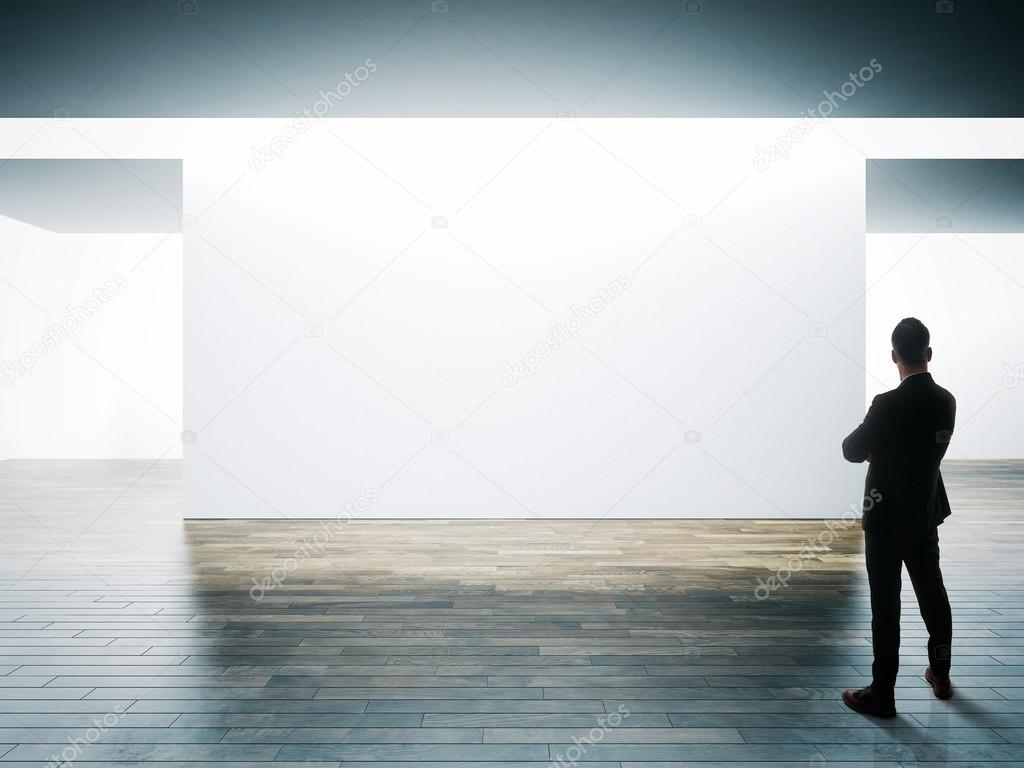 Businessman opposite big white wall Stock Photo by ©kantver 97053938