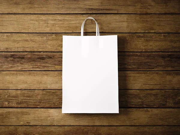 White paper shopping bag on the wooden background. In focus. Horizontal. 3d render — 스톡 사진