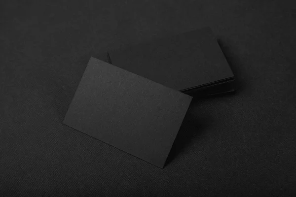 Pila de tarjetas de visita negras en blanco sobre fondo textil — Foto de Stock
