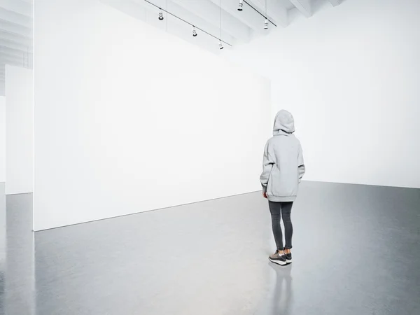 Jovem mulher na galeria moderna olhando para a tela em branco . — Fotografia de Stock