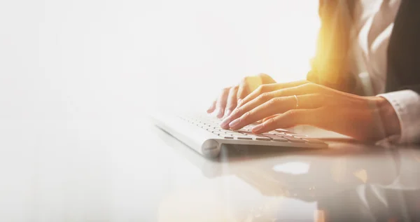 Photo rapprochée de mains féminines tapant du texte sur un clavier sans fil. Effets visuels, fond blanc — Photo