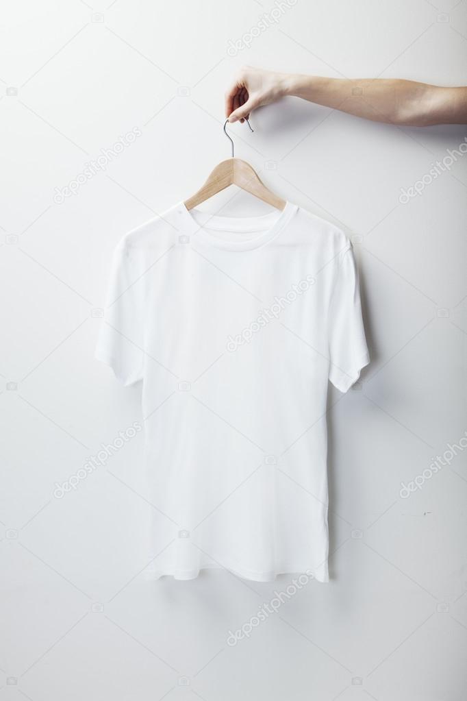 Photo of white tshirt hanging female hand