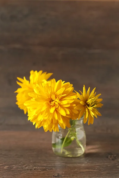 Höstens gula blommor på rustika bord — Stockfoto