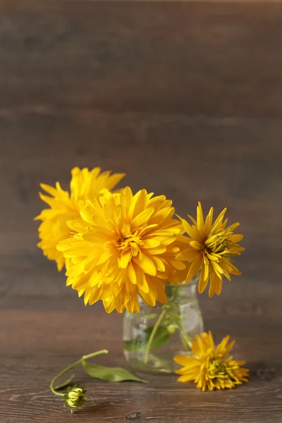 Осенние желтые цветы на деревенском столе — стоковое фото