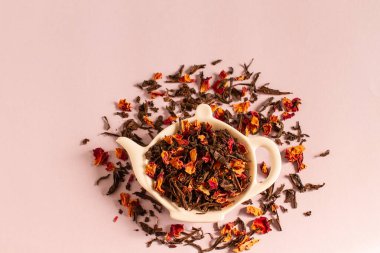 Çaydanlık şeklinde bir tabakta, gül yaprakları ve siyah çay yapraklarından gelen kuru çay.