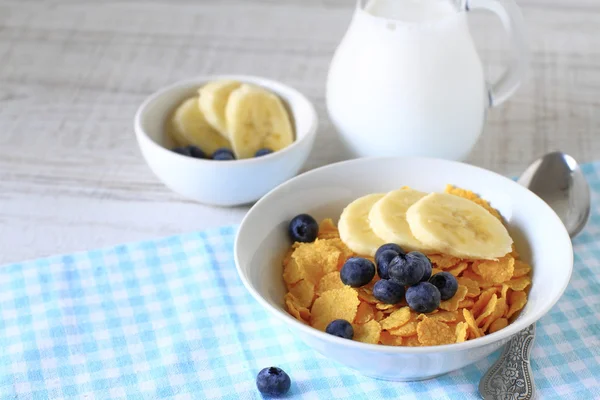 Płatki śniadaniowe z jagody, banany i mleko na rustykalne — Zdjęcie stockowe