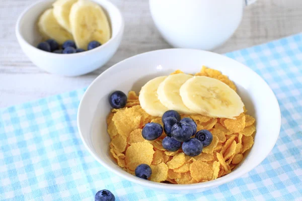 Breakfast cereal with blueberries, bananas and milk on a rustic — Stock Photo, Image