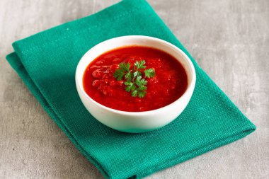 Beyaz kasede otlu ev yapımı domates sosu.