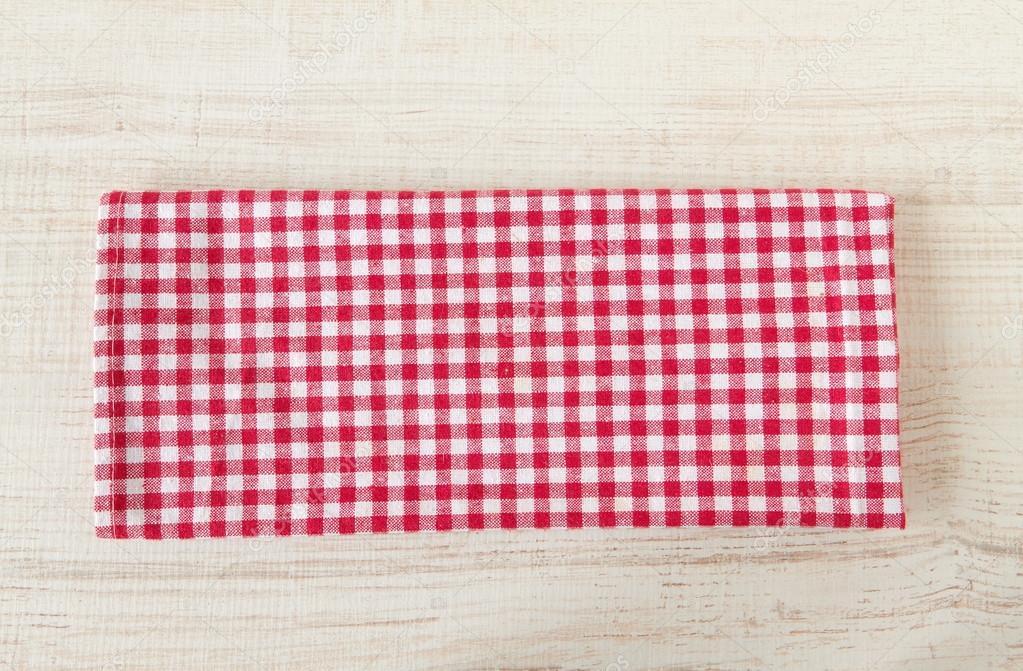 Red towel over wooden kitchen table.