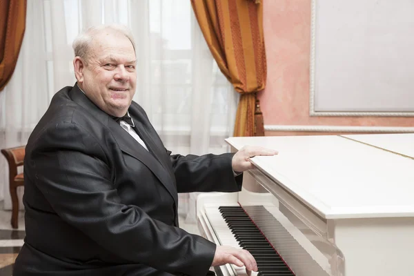 Volwassen muzikant een witte piano spelen — Stockfoto