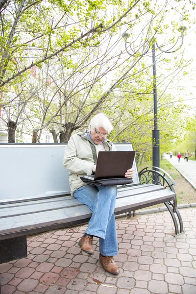 老人在户外使用便携式计算机 — 图库照片