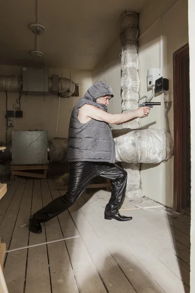 Ladrão armado com uma arma no sótão — Fotografia de Stock