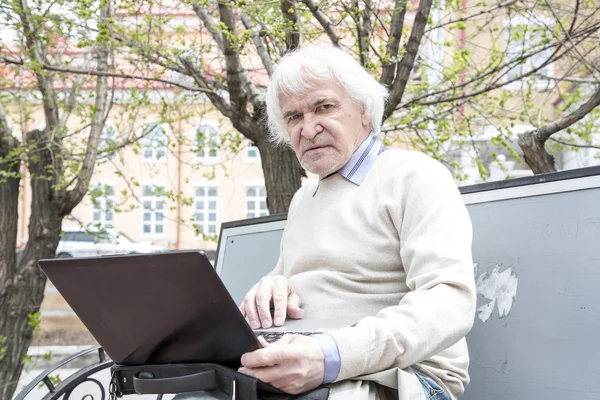 Senior benutzt Laptop im Freien — Stockfoto