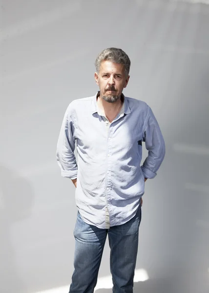 Portrait of a man standing on a gray background — Stock Photo, Image