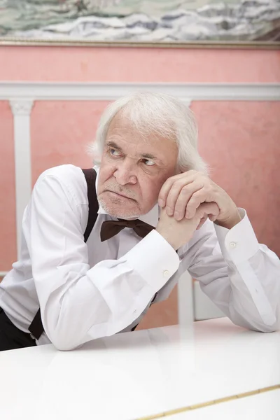 Mature musician playing a white piano — Stock Photo, Image