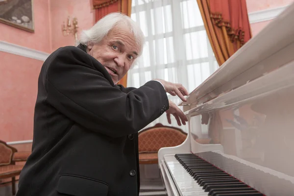 Volwassen muzikant een witte piano spelen — Stockfoto