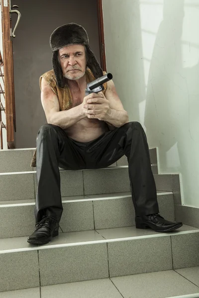 Вооруженный грабитель с пистолетом на аварийной лестнице — стоковое фото