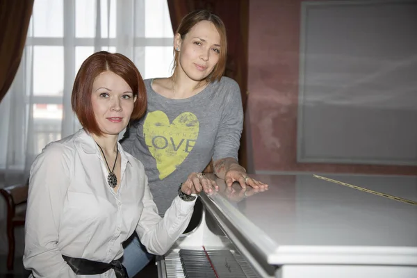 Två Vackra Ryska Kvinnor Vid Ett Vitt Piano Porträtt — Stockfoto