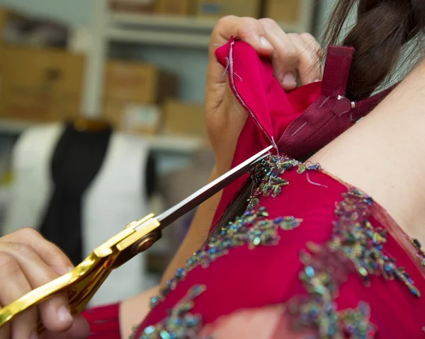 Designer adjusting dress on model — Stock Photo, Image