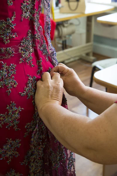 Fashion designer adjusting dress on model — Stock Photo, Image