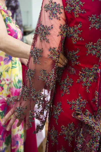 Fashion designer adjusting dress on model — Stock Photo, Image