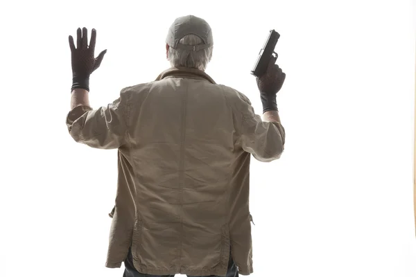 Пожилой человек с пистолетом сдаётся — стоковое фото