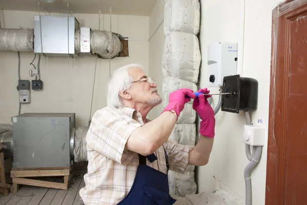 Homme fixant la pile de ventilation — Photo