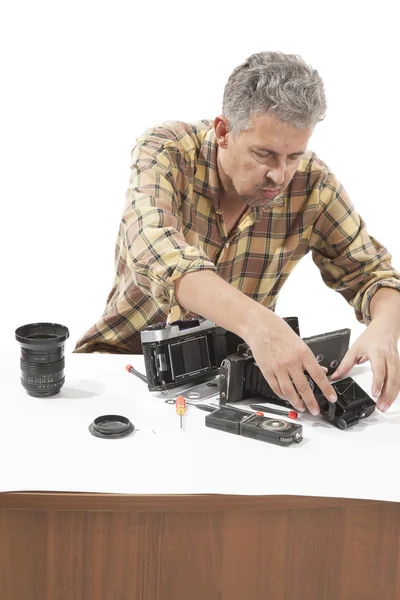 Homem verificando uma câmera antiga — Fotografia de Stock