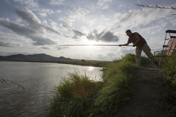 Pescador pescando en un río — Foto de Stock