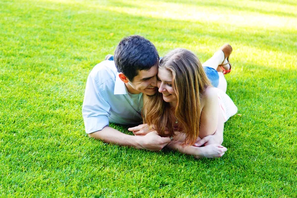 Paar liegt auf grünem Gras — Stockfoto