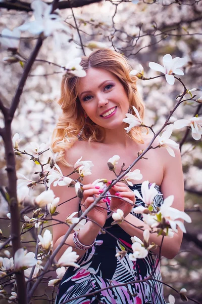 Beleza mulher sorridente perto de magnólia branca — Fotografia de Stock