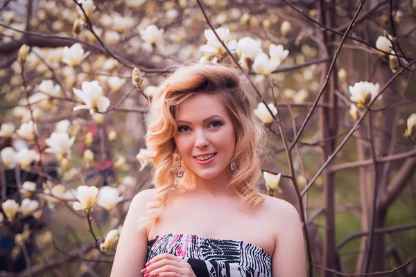 De lachende vrouw schoonheid in de buurt van witte magnolia — Stockfoto