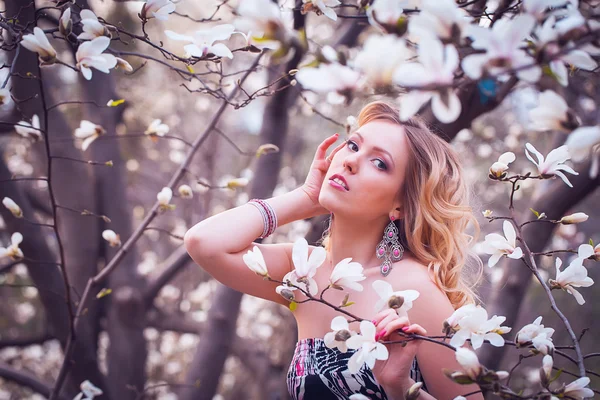De lachende vrouw schoonheid in de buurt van witte magnolia — Stockfoto