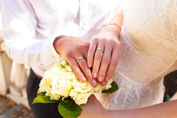 Hands and rings on wedding bouquet — Stock Photo, Image