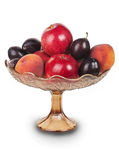Red apples, plums and peaches in a glass vase — Stock Photo, Image