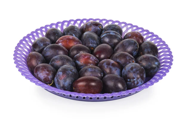Blaue Pflaumen in einem violetten Teller — Stockfoto