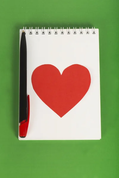 Coeur rouge avec un stylo noir sur carnet blanc — Photo